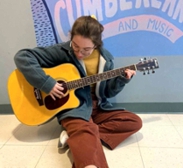 Student at Cumberland High School enjoying strumming Sid's guitar